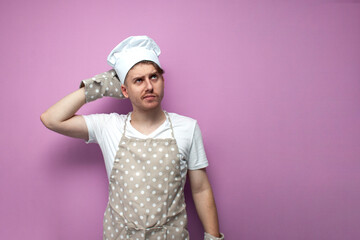 confused baker in uniform scratching the back of his head with his hand on a pink background and...