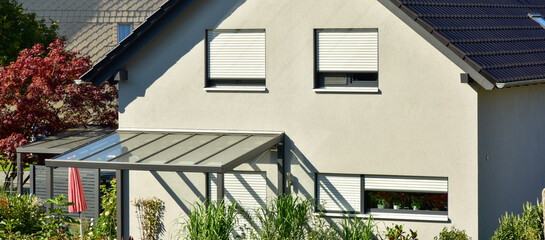Sonnendach / Pergola als Sonnenschutz auf der Terrasse eines neu gebauten Wohnhauses