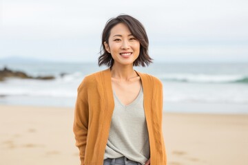 Cheerful young woman smiling at camera on beach vacation