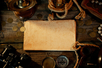 Treasure island concept on a wooden table background. Sheet of paper for text or map