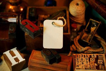 Paper label beside retro type objects and old wooden typographic blocks. Letters and numbers....