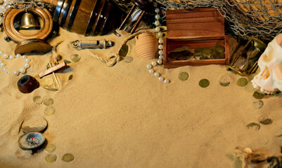 Treasure island theme. Frame on the sand among coins, marine vintage and marine elments. Frame on...
