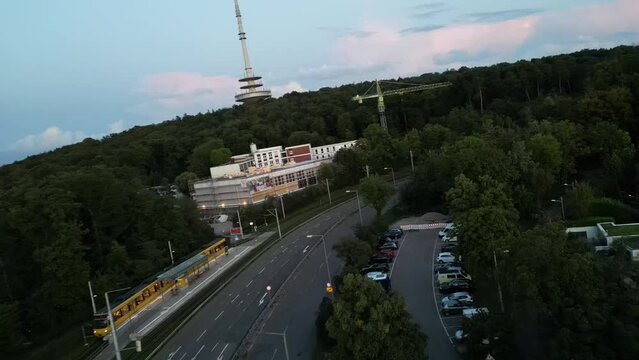 In diesem fesselnden FPV-Drohnenshot f&auml;hrt die Kamera &uuml;ber eine belebte Stra&szlig;e mit Autos und einer U-Bahn, bevor sie Richtung Wald fliegt.