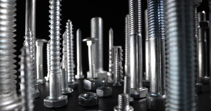 metal screws, bolts and fasteners on black background
