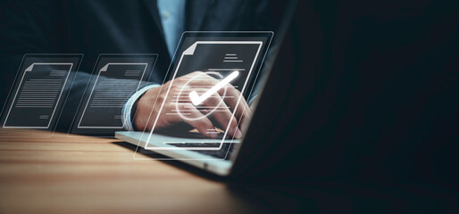 Businessman using laptop computer and touching to online electronic paper for approve ISO quality...