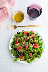 Rocket (arugula) and lamb's lettuce salad with grapefruit, pomegranate seeds, black olives, capers, walnuts, and mustard vinaigrette dressing
