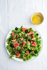 Rocket (arugula) and lamb's lettuce salad with grapefruit, pomegranate seeds, black olives, capers, walnuts, and mustard vinaigrette dressing