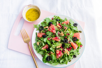 Rocket (arugula) and lamb's lettuce salad with grapefruit, pomegranate seeds, black olives, capers, walnuts, and mustard vinaigrette dressing