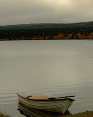 Obraz premium Shore of a lake in an autumn landscape with a boat