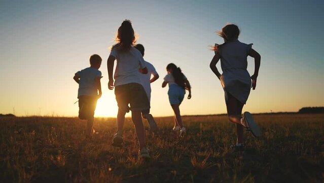 children running in the park silhouette. people in park. children a kid together run in park at sunset silhouette. group of children lifestyle run. happy family and little baby child summer
