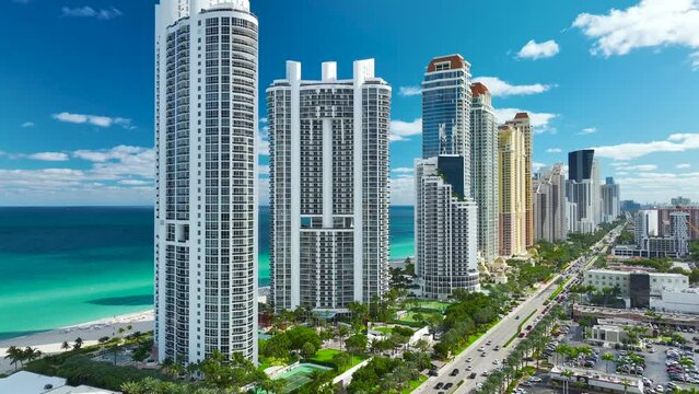Aerial view of Sunny Isles Beach city with congested street traffic and luxurious highrise hotels and condos on Atlantic ocean shore. American tourism infrastructure in southern Florida