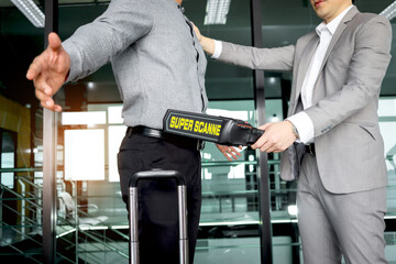 Security man holding metal weapon detector scanner for checking male passenger who going through procedure of physical inspection at entrance airplane gate. Airport security check before flight. © Stella