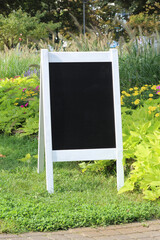 Vintage Black Chalkboard, blank welcome sign Mockup with white wooden frame, outdoors. Vintage wedding greeting sign mock up template.