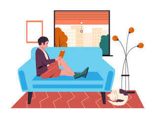 Man reading book on couch at home