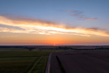 Blue violet red sunset sky background with evening curly rolling clouds may use for sky replacement