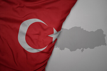 big waving national colorful flag and map of turkey on the gray background. - obrazy, fototapety, plakaty