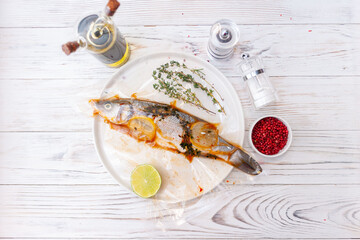 Raw fish sea bass with spices and herbs ingredients on white background