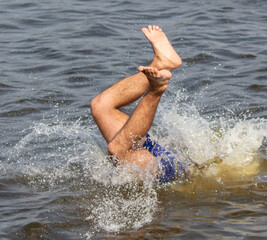 A man dives into the water of the lake