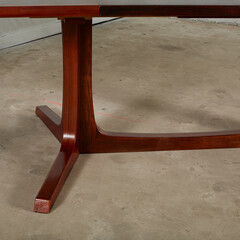 Exquisite rosewood splay-leg dining table. Rich red wooden furniture. Close-up detail photograph.