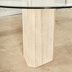 Luminous travertine stone dining table with a glass top. 
Stylish postmodern furniture. Close-up...