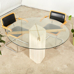Luminous travertine stone dining table with a glass top. 
Stylish postmodern furniture. Interior...