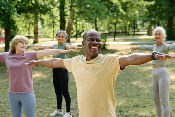 Group of happy senior people exercising in the park in the morning