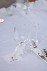 Wedding table with detail of glasses, cutlery and signs with name tags in the Czech language