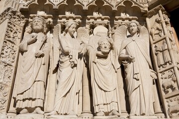 The Statues Around St. Denis Holding His Head At The Notre-Dame Cathedral; Paris, France