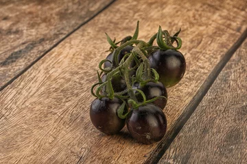 Foto op Plexiglas Ripe tasty black cherry tomato © Andrei Starostin