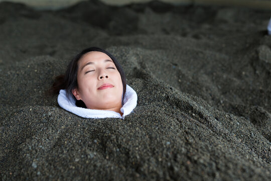 Woman enjoy hot sand bath