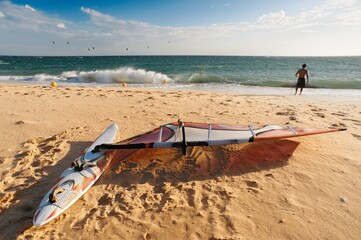 A Man On The Beach With His Windsurfing Board; Tarifa, Cadiz, Andalusia, Spain