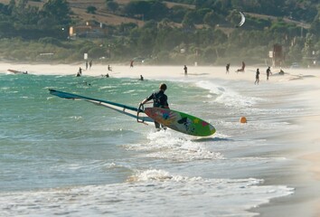 A Man On The Beach With His Windsurfing Board; Tarifa, Cadiz, Andalusia, Spain