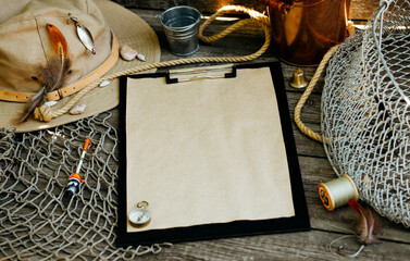 Clipboard with vintage paper for your text logo or info. Fishing tackles, cap, net, bucket on a...