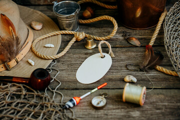 Fishing theme. Oval label with hooks, bucket, fishing buoy, compass and fish string on wooden...