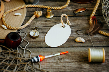 Fishing theme. Round label with hooks, bucket, fishing buoy, compass and fish string on wooden...