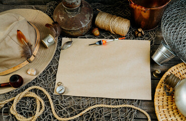 Vintage paper for your text logo. Fishing tackles, cap, net, bucket on a wooden background.