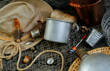 Metal mug with place for text or logo, lay on net and old wood table. fishing background