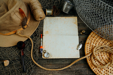 Vintage paper for your text logo. Fishing tackles, cap, net, bucket on a wooden background.	
