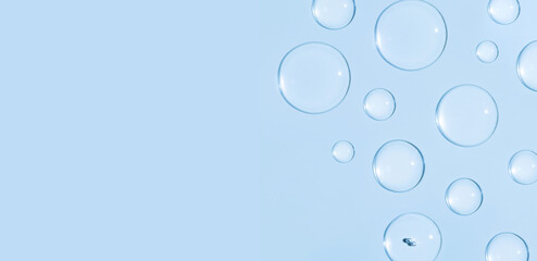 round drops of transparent gel serum on blue background