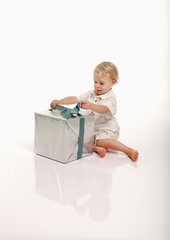 Toddler Unwrapping Gift Against White Background