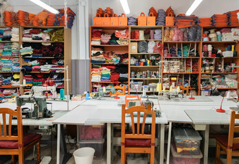 Interior of a workshop for sewing clothes and textiles. Without people. The workroom of seamstresses and dressmakers. Industrial scale.