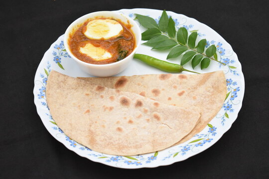 tasty chapathi chapati with egg curry masala gravy white plate background