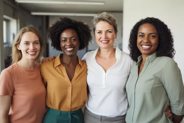 Fototapeten Portrait of a diverse group of smiling ethnic business women standing together in the office. Ambitious happy confident professional team of colleagues embracing while feeling supported and empowered © Super2
