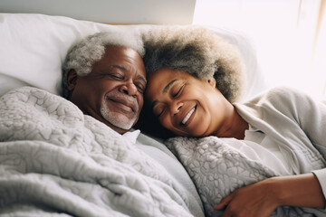 Happy senior couple lying in bed and embracing at home