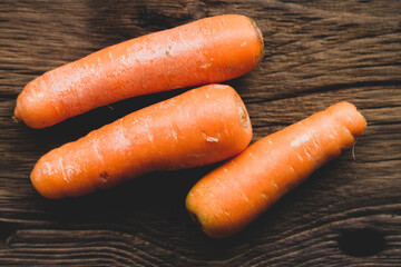 Fresh carrots on worn wood, close-up image