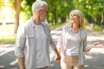 Loving Mature Couple Having Fun While Walking In Park Together