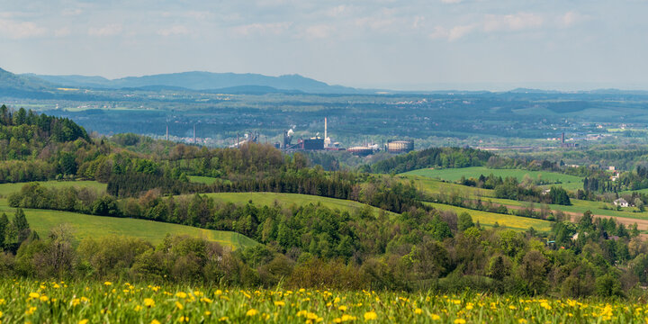 Trinecke zelezarny factory with rural landscape around and hills of Moravskoslezske Beskydy mountains from meadow above Leszna Gorna village in Poland