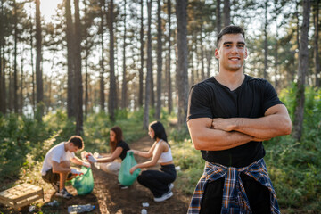 Portrait of caucasian male teenager activist volunteer during picking up waste garbage plastic...