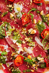 beef carpaccio with fresh herbs and tomatoes