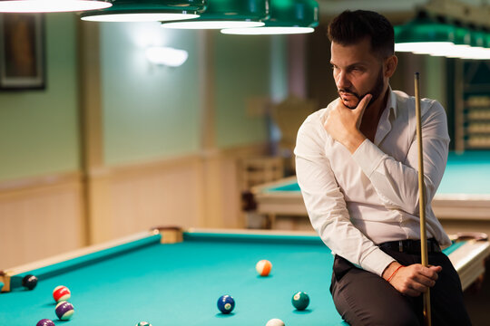 Billiard player calculate trajectory pathway at billard table or snooker american billiards pool sport game